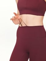 Close-up front view of the BEYOURA Estelle Stretch & Stash luxeFIT Leggings in maroon with an adjustable waistband