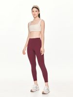 Full front view of the BEYOURA Giselle Broad Strap luxeFIT Sports Bra in off-white styled with marroon leggings