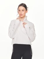 Close-up front view of model posing with the zipper of the BEYOURA Madeleine Cropped luxeFIT Lightweight Pullover in off-white