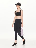 Full side-front view of the BEYOURA Giselle Broad Strap luxeFIT Sports Bra in taupe styled with hat and a water bottle