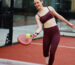 Woman playing tennis in breathable activewear, reflecting moisture-wicking performance and stylish athleisure for active days.